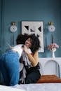 Woman in Black Shirt and Blue Denim Jeans Sitting on White Chair