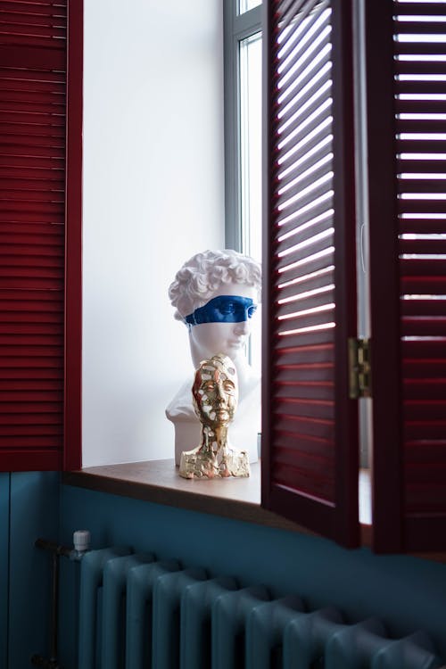 Decorative Head Busts on a Window Sill