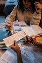 Woman in Beige Sweater Holding Black Pen Writing on White Paper