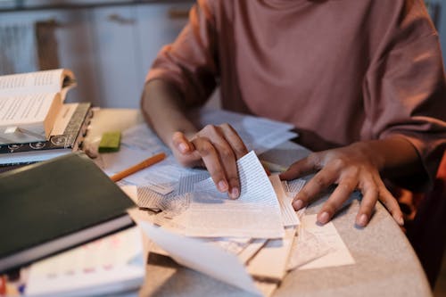 Girl Sitting at the Table with Textbooks and Studying 