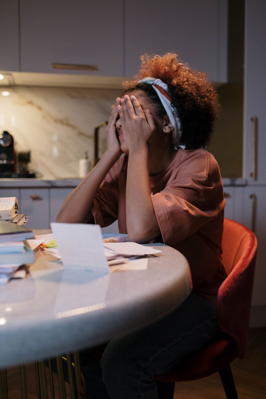 Mulher cansada e preocupada à mesa da cozinha