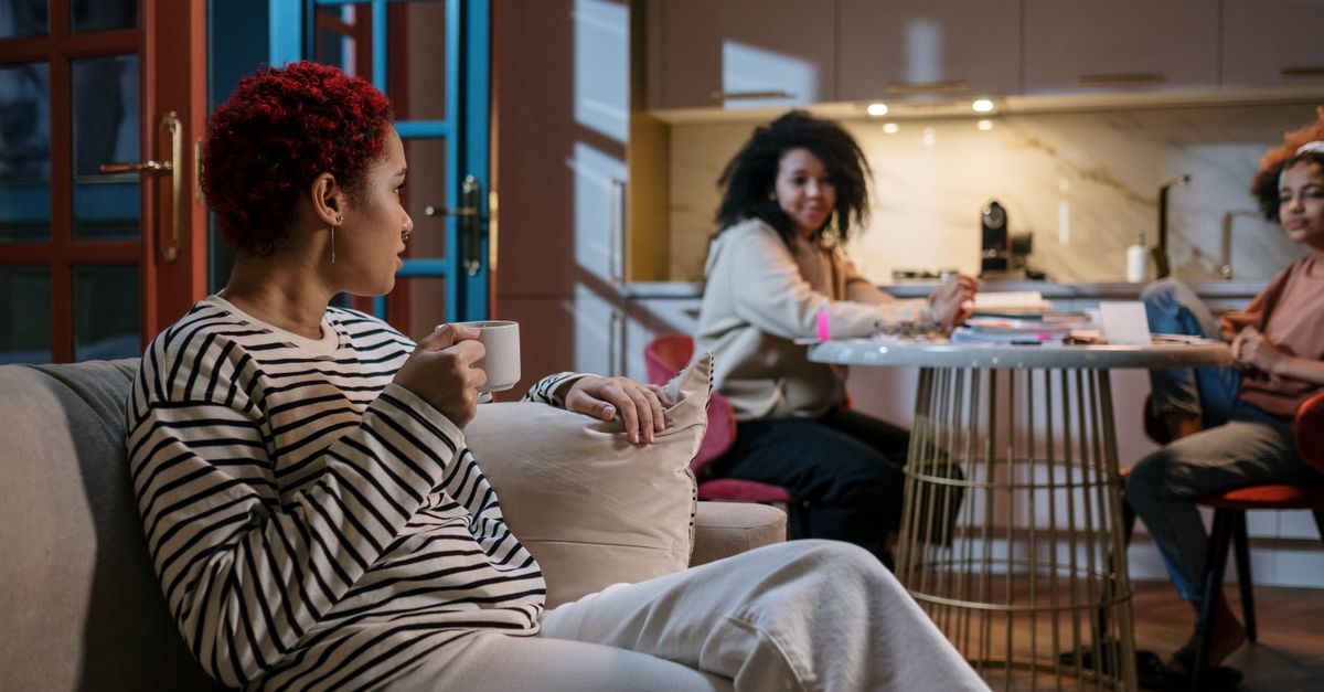 Three women enjoying a relaxed gathering in a stylish and cozy home environment.