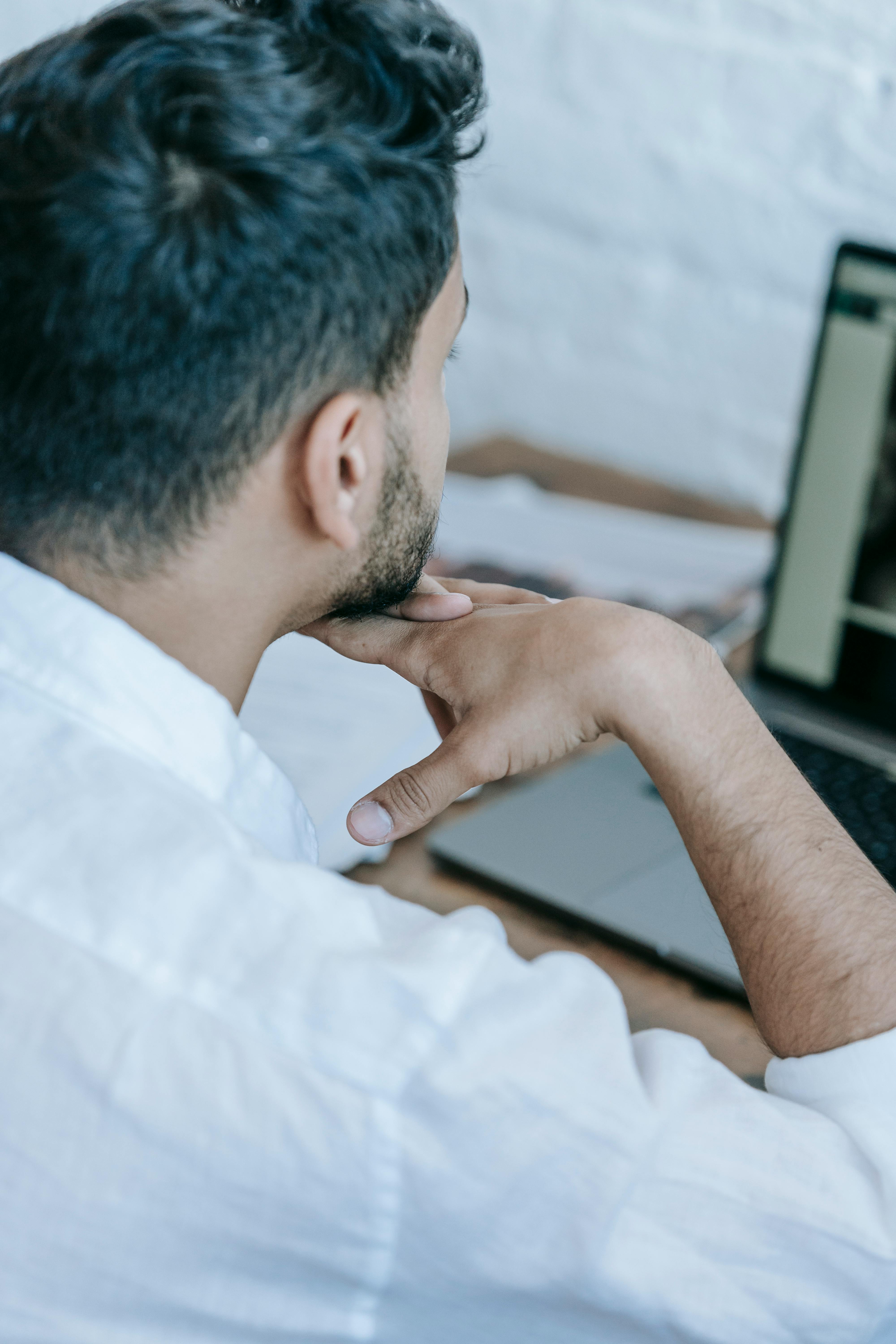 crop concentrated man working on laptop