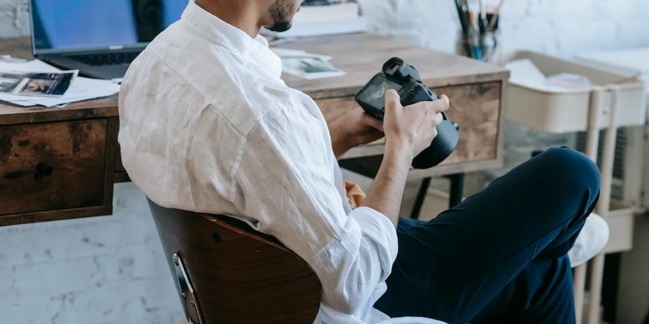 A content creator at a desk reviewing a camera, the kind of repurposing that turns one article into many social posts.
