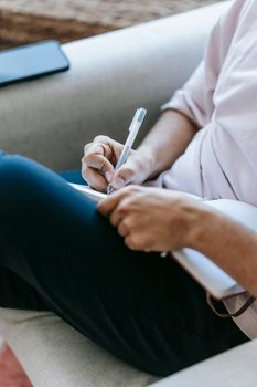 Crop unrecognizable person writing in diary