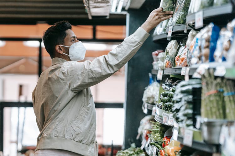 Indian Man Choosing Groceries In Supermarket