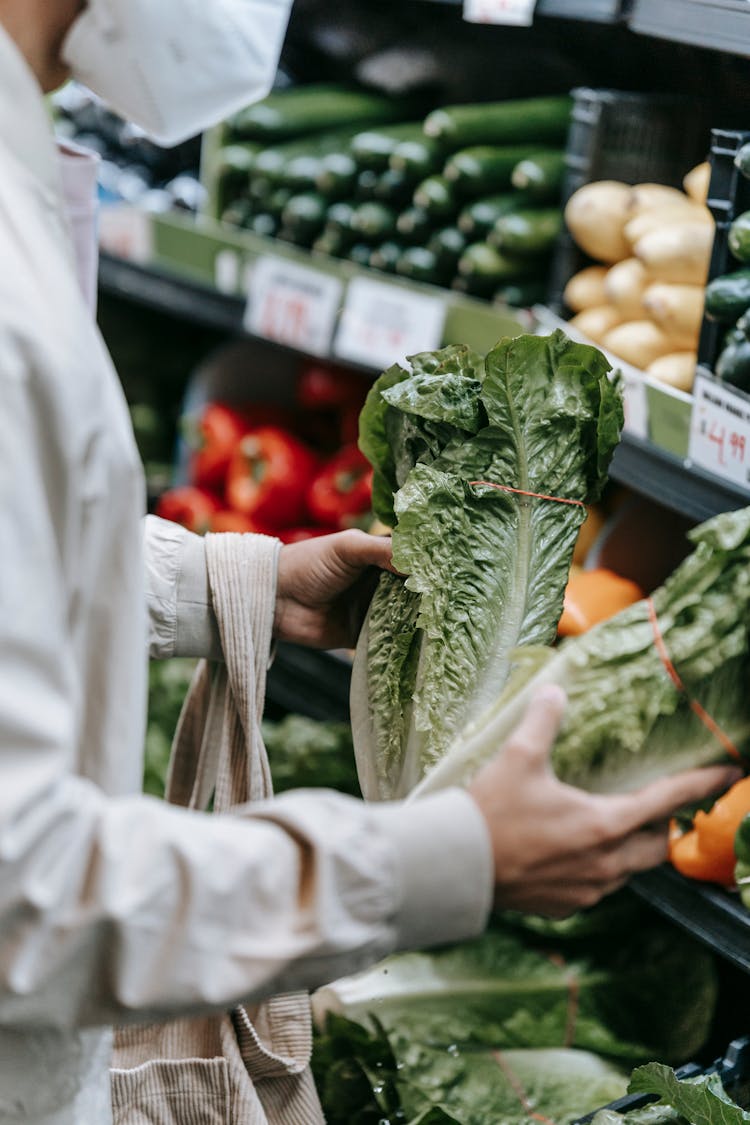 Unrecognizable Customer In Medical Mask With Lettuce In Supermarket