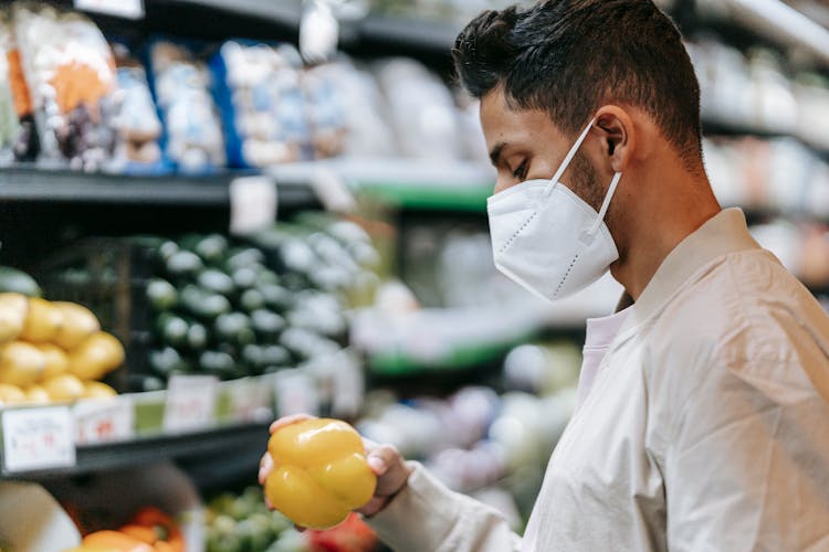 Indian Man In Protective Mask Choosing Bell Pepper