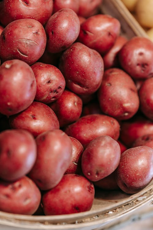 From above of fresh raw red potatoes in straw basket in local grocery market