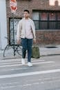 Trendy ethnic man with natural bag crossing urban road