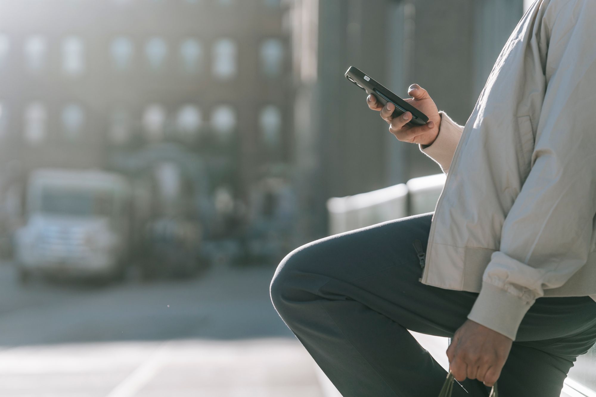 Persona sostiene un iPhone con un navegador web abierto mientras camina por la calle