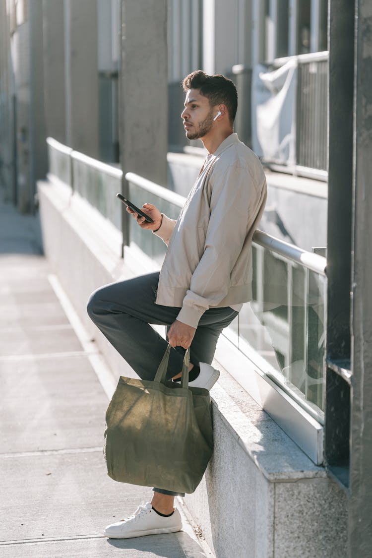 Trendy Indian Man With Smartphone And Eco Bag In Town