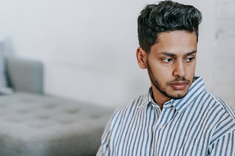 Lonely Indian Man In Striped Shirt At Home