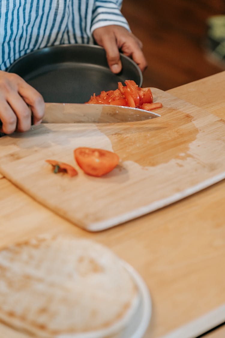 Crop Ethnic Man With Bowl And Cut Tomato In Kitchen