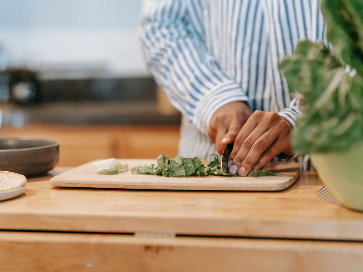 Person chopping vegetables in a home kitchen without a clear meal prep plan