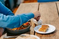 Man having supper with tasty dish and baklava