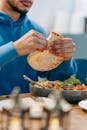 Man eating white bread at table with tasty meal