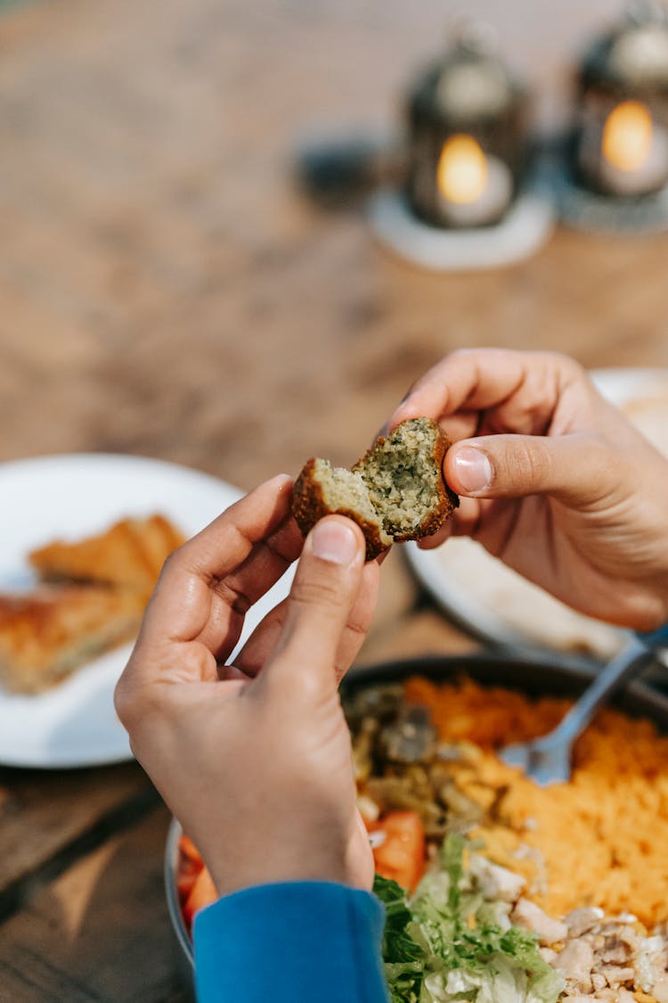 Man With Tasty Meat In Hands At Table With Food