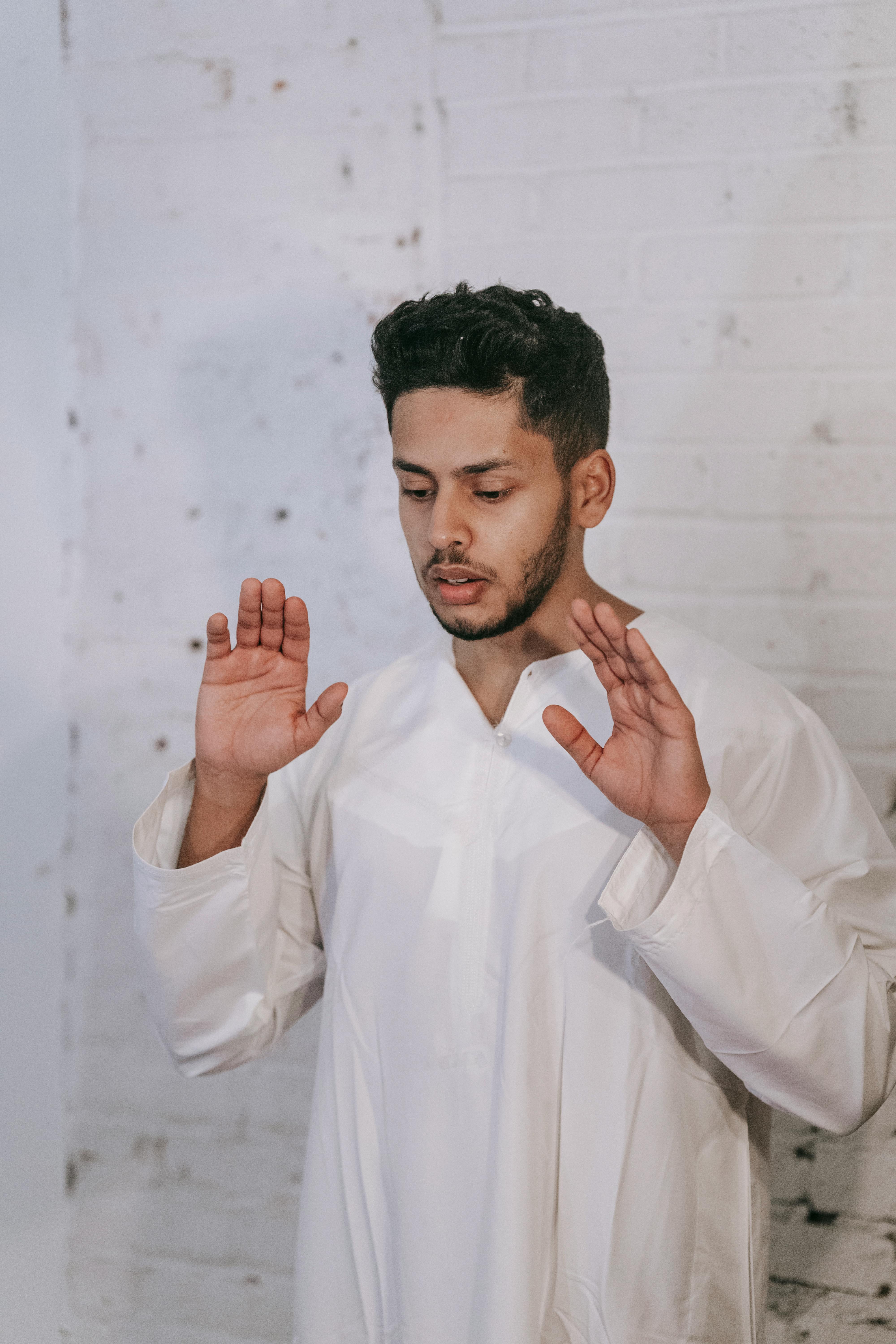 man in white thobe praying