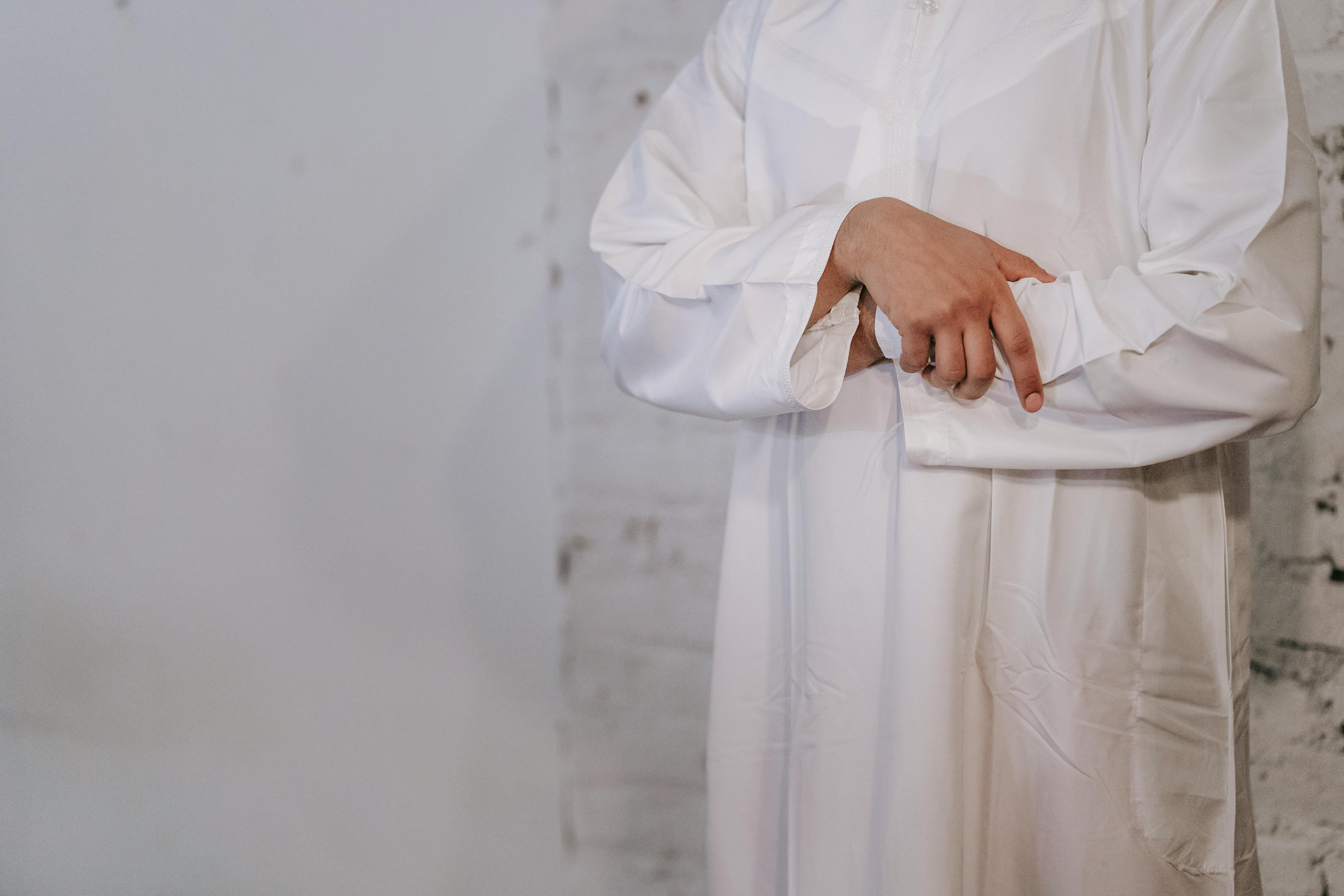 man in white thobe praying