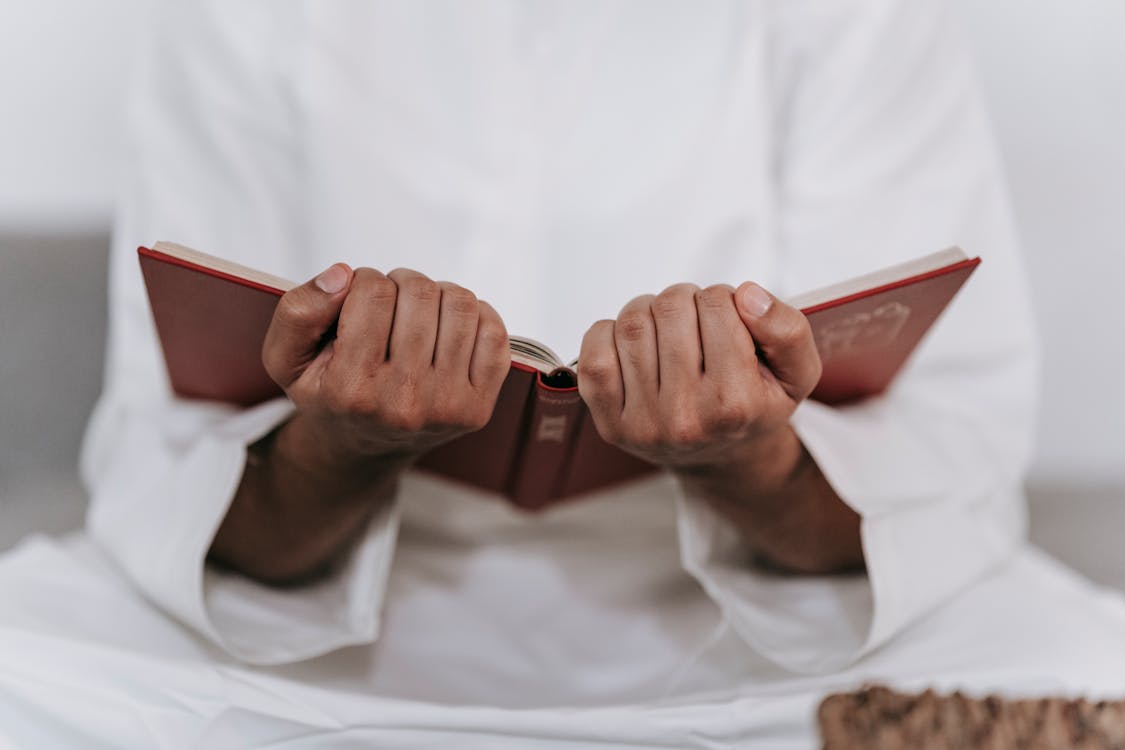 Free Person Holding a Quran Stock Photo