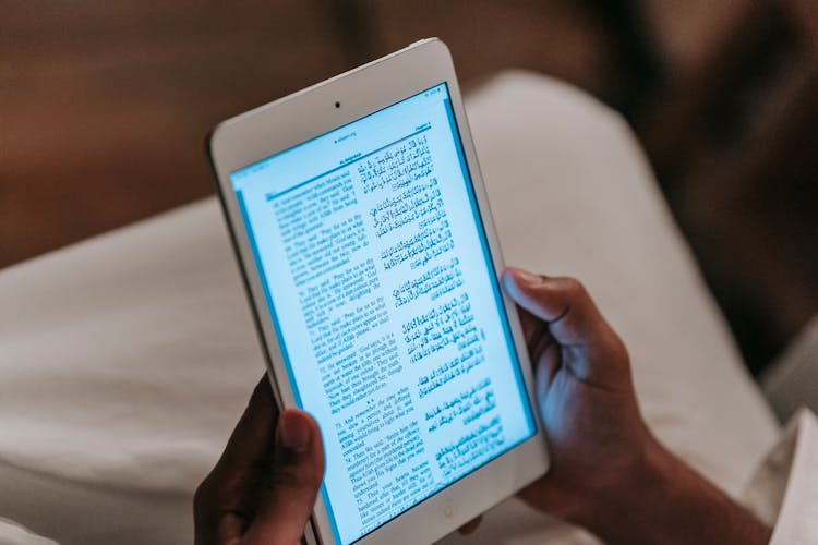 Person Reading Book On Tablet