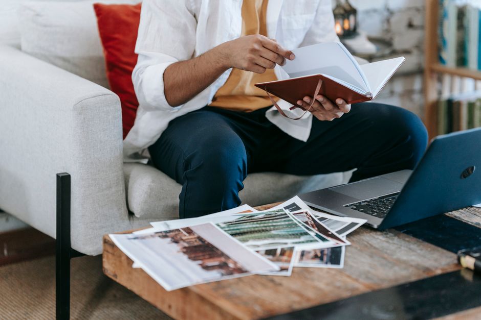 digital transformation skills every professional needs - Man reviewing images and notes at a cozy workspace with laptop and notebook.
