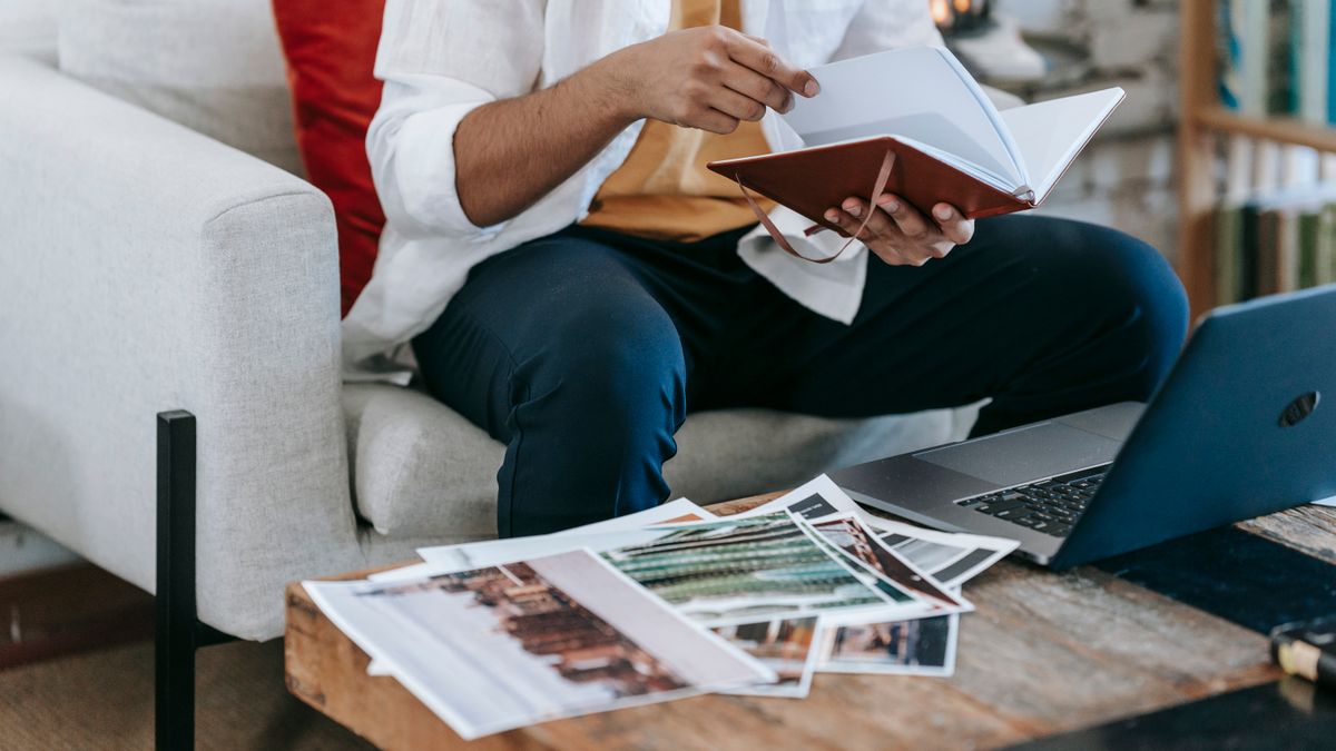 Designer planning AI SaaS onboarding flows beside a laptop and notes