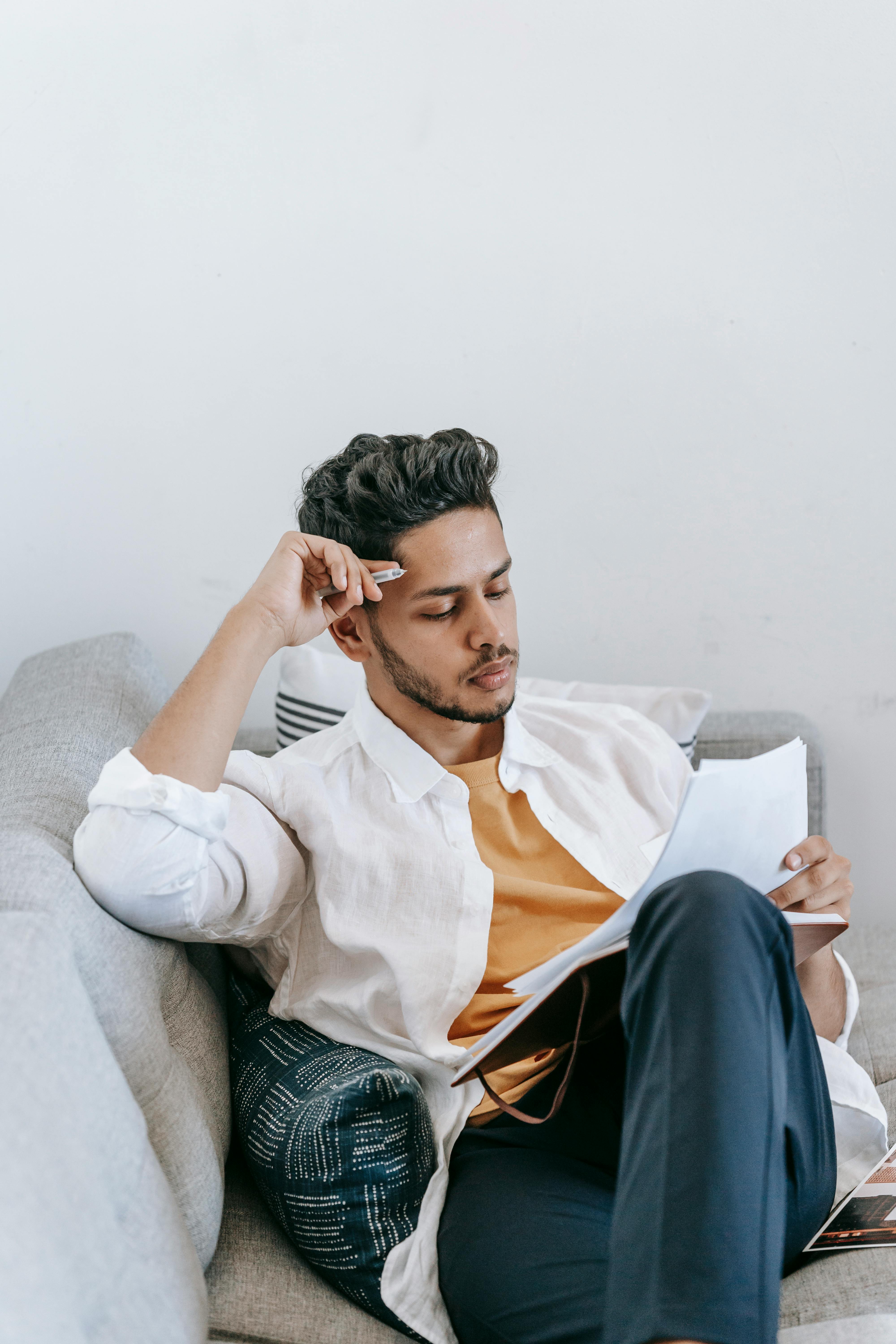 man reading papers on couch