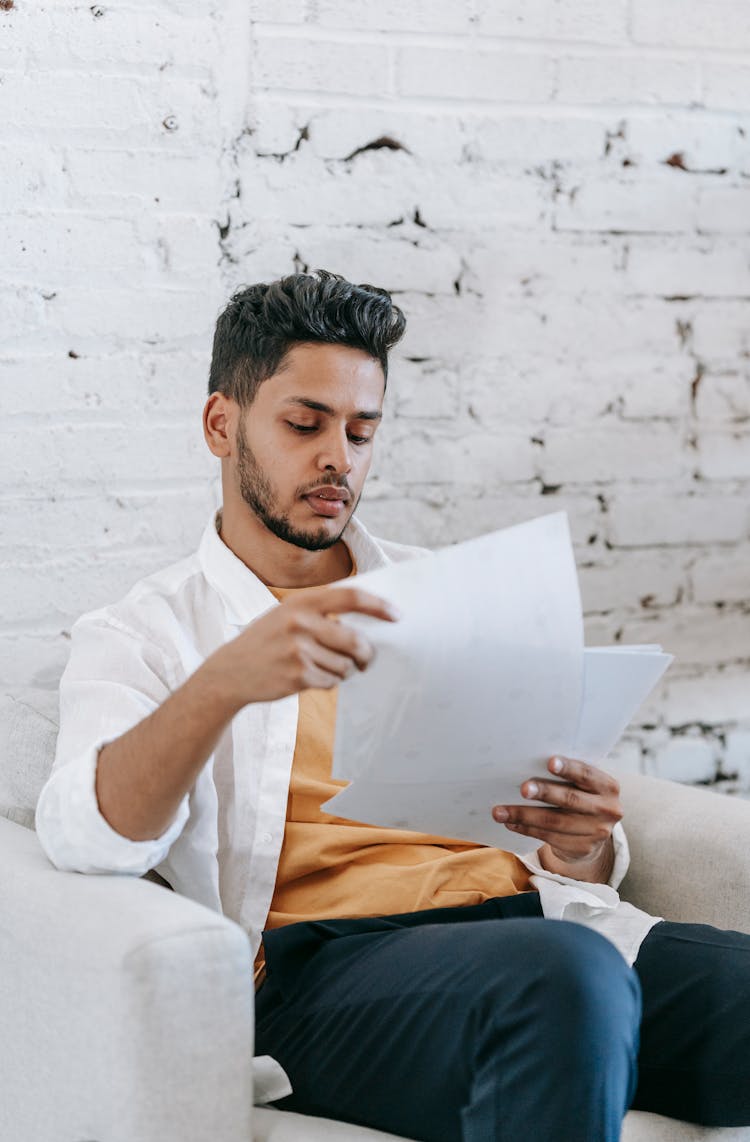 Serious Young Man Examining Documents