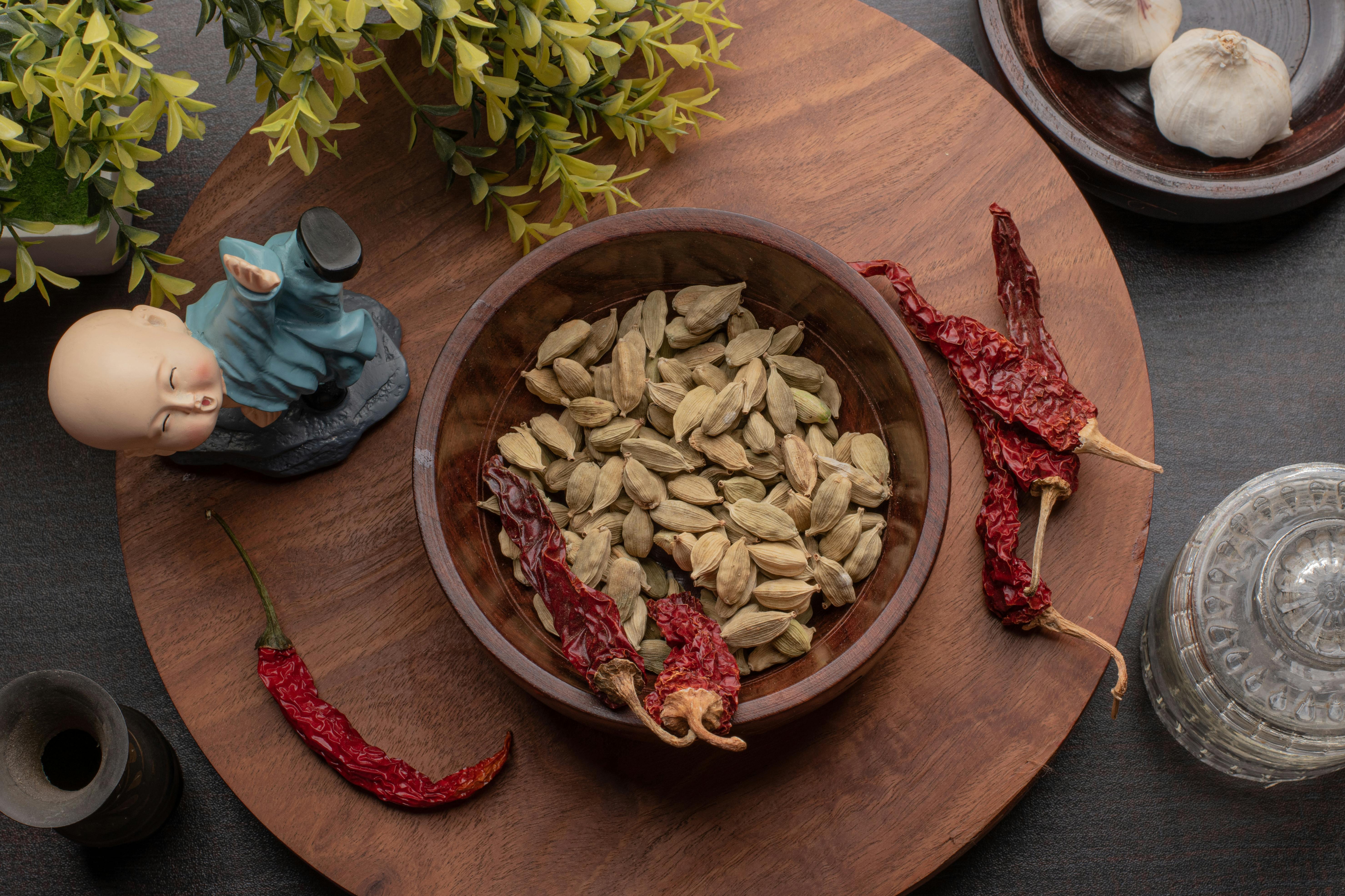 Free Overhead Shot of a Bowl with Cardamoms Near Chili Peppers Stock Photo