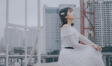 A Woman in White Skirt Sitting with Her Eyes Closed