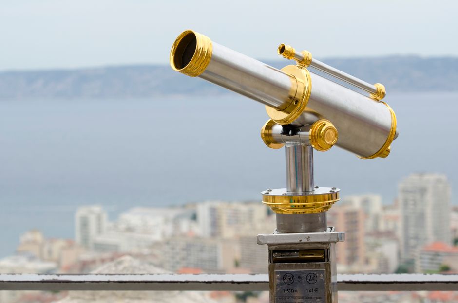 A coin operated telescope overlooking the cityscape of Marseille, France on a clear day.