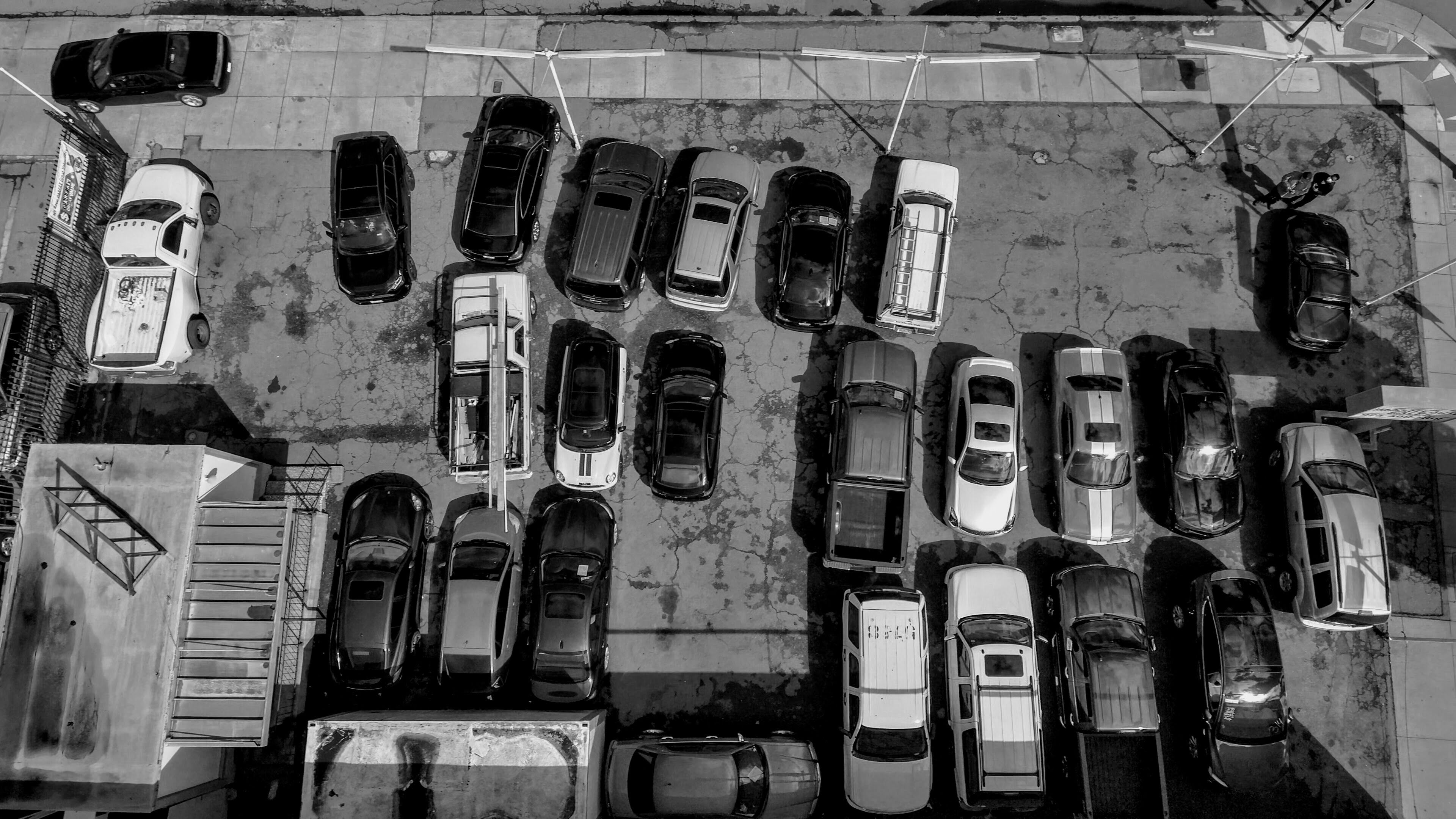 Grayscale Photo of Cars Parked on Parking Lot · Free Stock Photo
