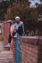A Man Sitting on a Gatepost