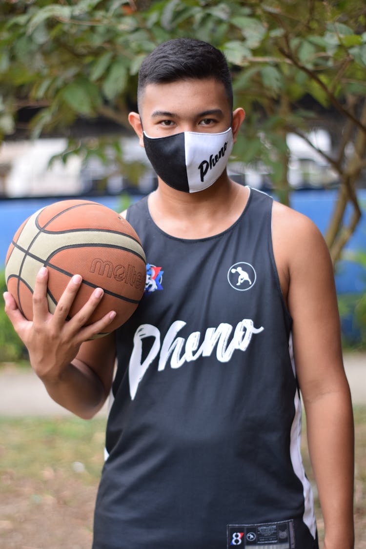 Man Wearing Face Mask Holding A Basketball