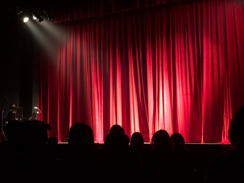 People at Theater with Red Curtain