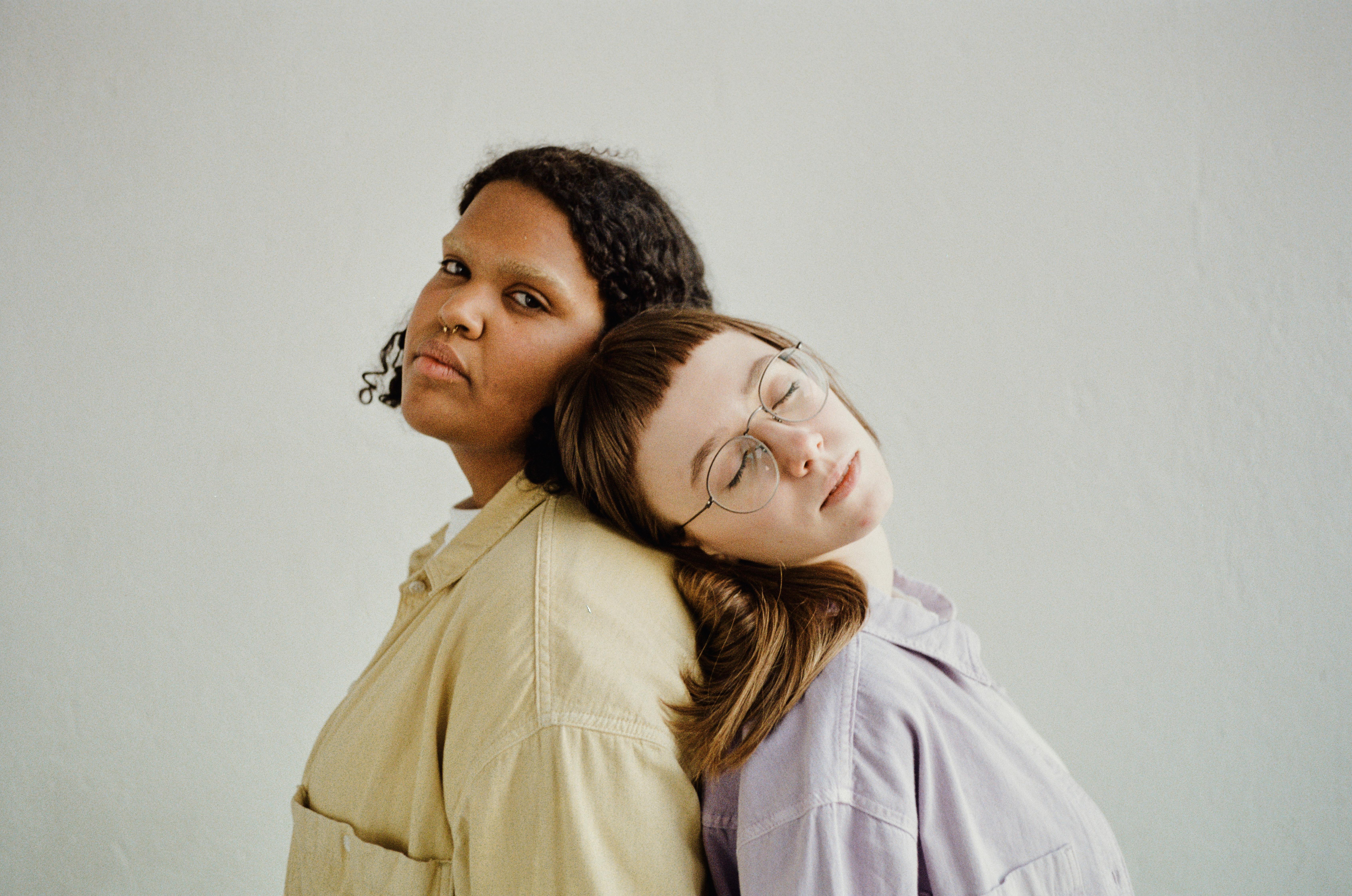 Two people standing back to back showcasing unity and diversity.