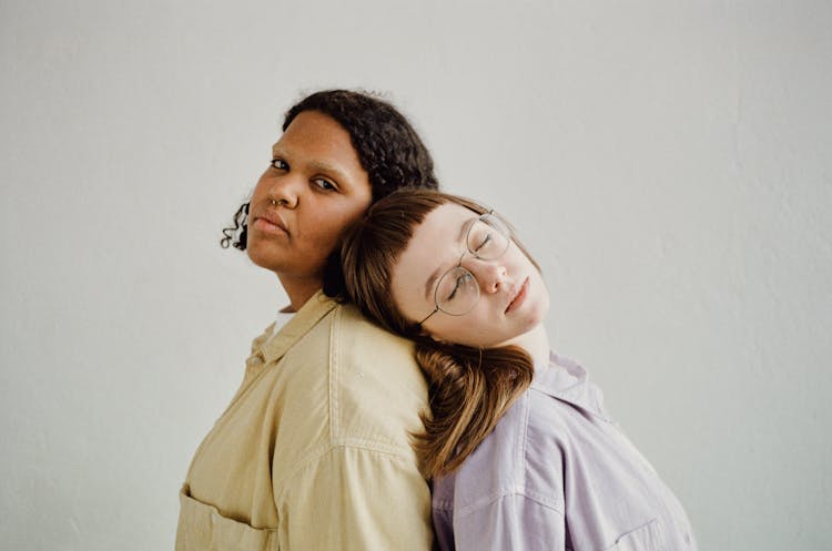 Young Women Standing Back To Back