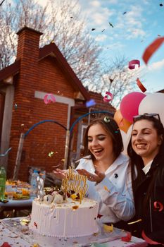 A lively outdoor birthday party with cake, smiles, and confetti celebrating friendship and happiness.