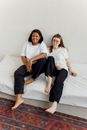 2 Women Sitting on White Bed