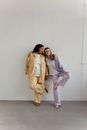 Woman in Yellow Coat Standing Beside Woman in White Hijab
