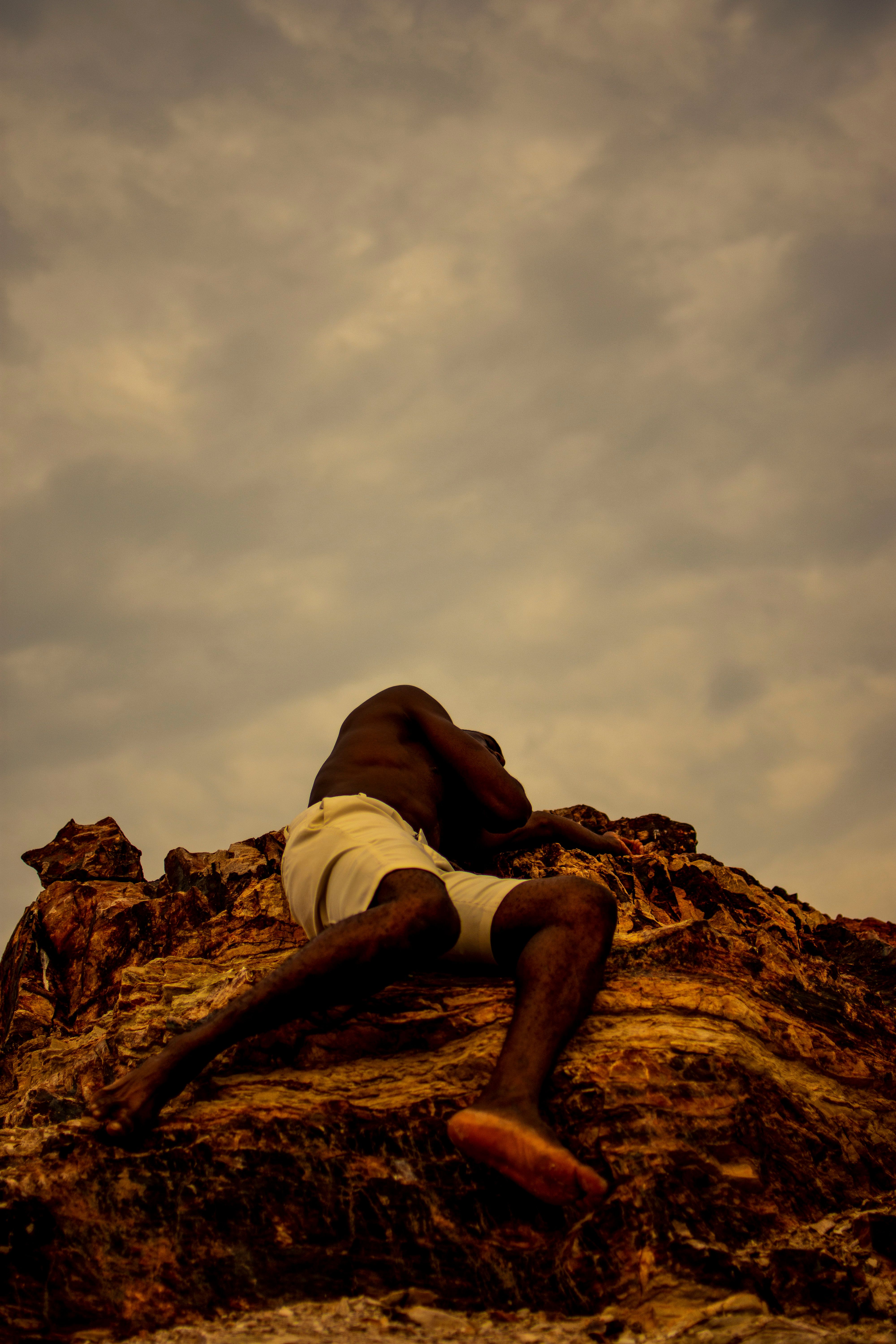 A Shirtless Man Lying on a Rock · Free Stock Photo