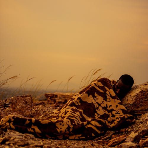 Photograph of a Man Sleeping on a Rock