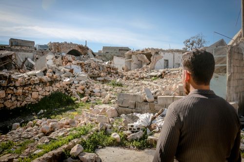 Free A man looks at the rubble of desolated buildings in Idlib, showcasing the impact of conflict. Stock Photo