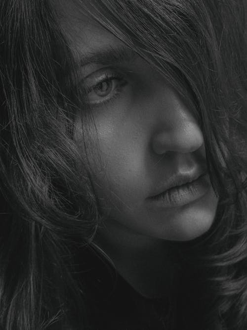 Grayscale Photo of a Woman's Hair Covering Her Eye