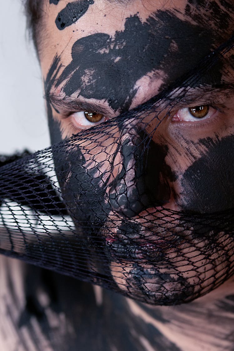 Photograph Of Black Paint And Mesh On A Person's Face