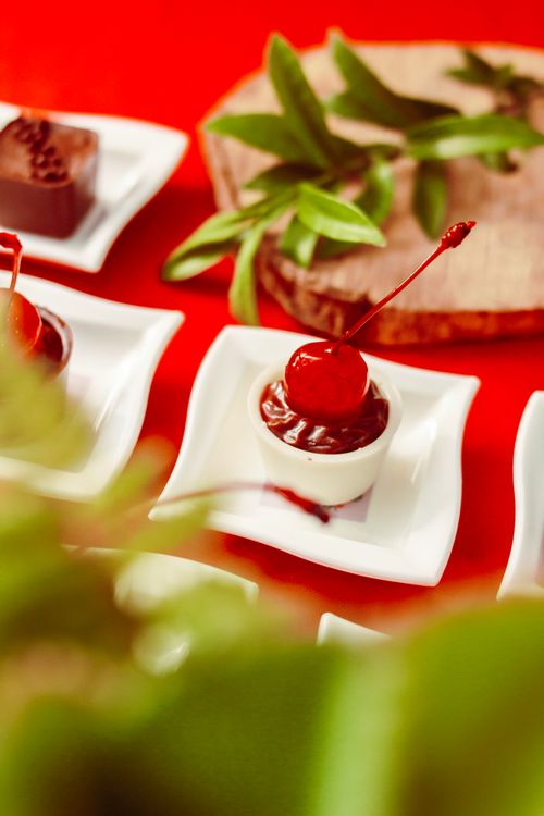Free An enticing close-up of a chocolate cherry dessert garnished with fresh leaves on white plates. Stock Photo