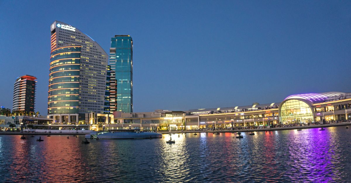 Stunning view of Dubai Creek waterfront with modern skyscrapers and reflected city lights.