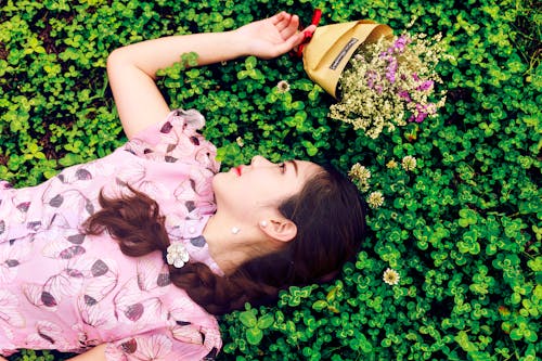 ピンクと黒の花柄のブラウスを着ている女性